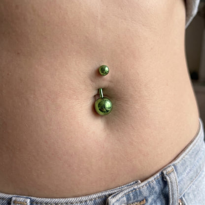 A green belly button bar in the belly piercing of a female model.
