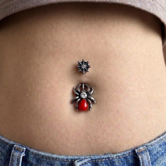 A red spider belly button ring in the belly piercing of a female model.