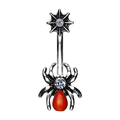 Decorative belly button ring with spider design and red stone on a white background